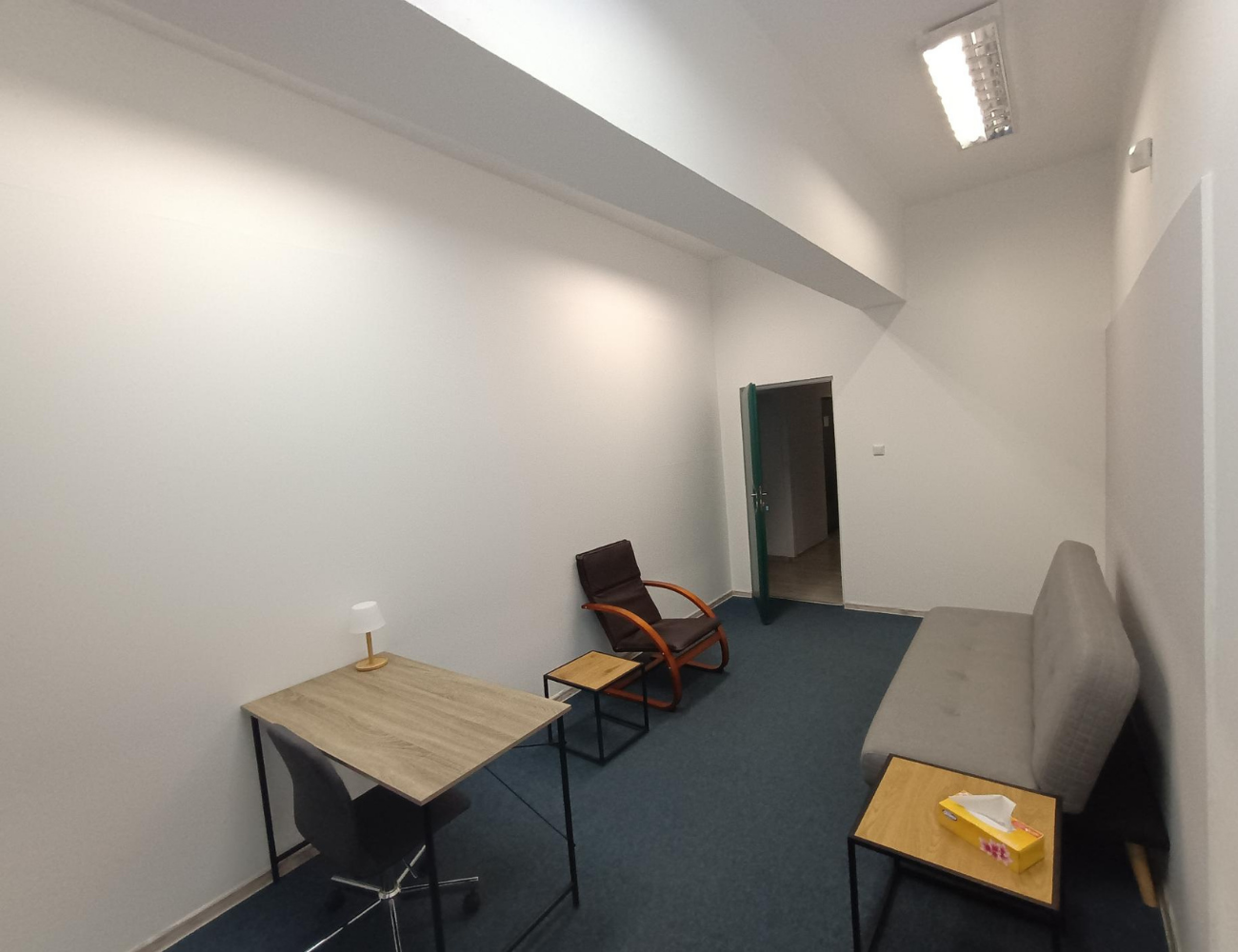 Wnętrze gabinetu psychologicznego Michała Jaskólskiego ul. Łagiewnicka 118b w Łodzi - przestronna sala konsultacyjna z wygodnymi fotelami, biurkiem i profesjonalnym oświetleniem