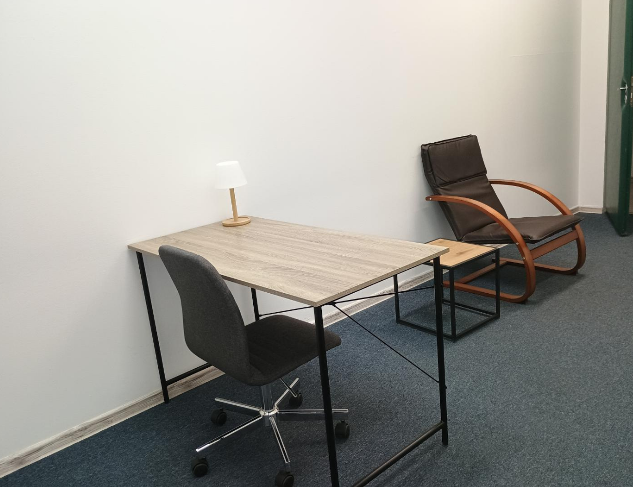 Sala konsultacyjna gabinetu psychologicznego Michała Jaskólskiego przy ul. Łagiewnickiej 118b w Łodzi - nowoczesne wnętrze z biurkiem, wygodnymi fotelami i minimalistycznym designem